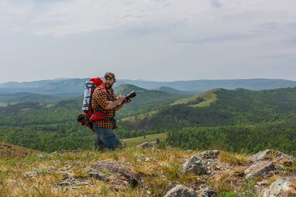 Een man met een camera op een berg. Wildlife fotograaf aan het werk. — Stockfoto