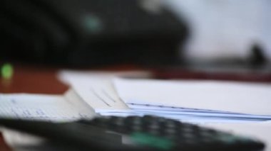 Bir adamın eli çıkartma kullanır ve belgeleri zımbayla tutturur..