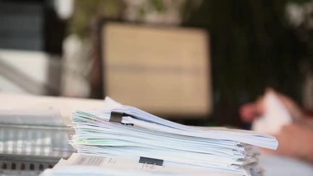 Un uomo analizza i documenti in ufficio e li impila in una pila - concentrarsi su una pila di documenti. — Video Stock
