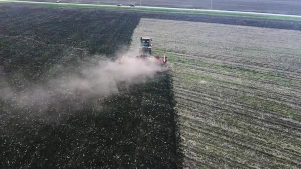 View from the drone: tractor plows field. Camera following the tractor — Stock Video