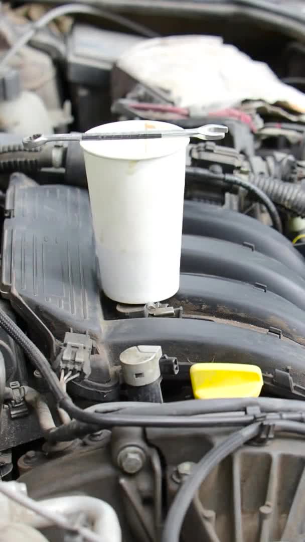 Vertical video. Repairman stirs coffee with a wrench. Close-up view. — Stock Video