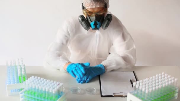 Vista frontal de un investigador en un laboratorio que observa una muestra de sangre enferma en un tubo de ensayo . — Vídeos de Stock