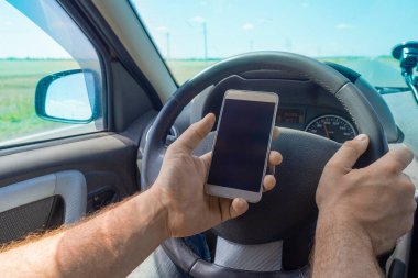 Araba kullanırken cep telefonu kullanan adam..