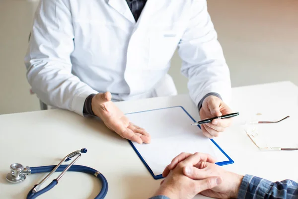 Doktor hastaya hastalığından ve sağlık sigortasının olanaklarından bahseder. Hasta ve doktor.