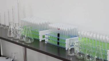 Laboratuvarda ellerin yakın çekimi raftan test tüpleriyle tutucuyu alır..