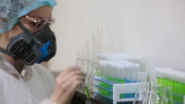 实验室里的一位女研究员把试管放在一个托架上. — 图库视频影像