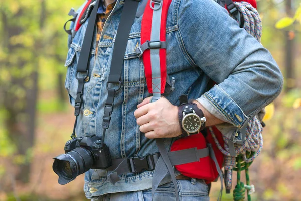 Крупный план человека с рюкзаком и фотокамерой в лесу. — стоковое фото