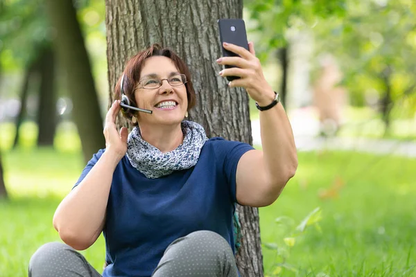 彼女のスマートフォンを使用してビデオ通話のための笑顔シニア女性. — ストック写真