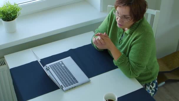 Starsza kobieta prowadzi rozmowę online. — Wideo stockowe