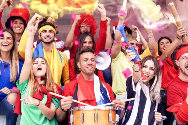 bir stadyum standları bir spor olayı izlerken çeşitli renklerde giyinmiş hayranları grup