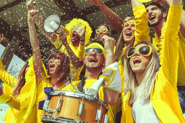 Gruppe gelb gekleideter Fans beobachtet ein Sportereignis — Stockfoto