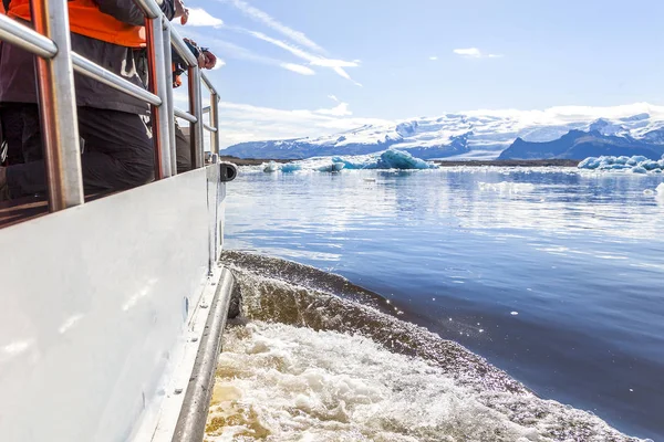 people sailing between icebergs in Jokulsarlon Lagoon Iceland with amphibian boat among melting glaciers