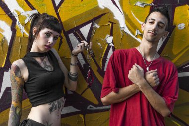 Genç bir çift kelepçe polis memuru ve bir duvar grafiti ile önünde mahkum ile oynarken erkek dövme