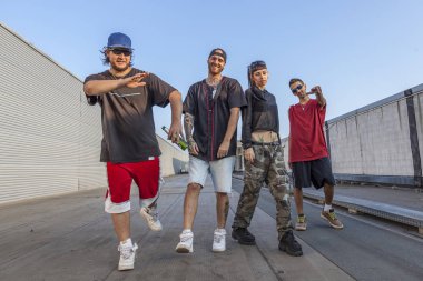 group of rappers posing on the metal rooftops of an abandoned building clipart