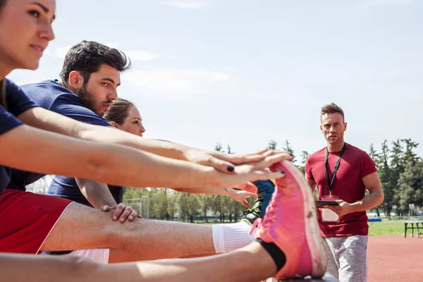 Gruppe Von Athleten Heizt Die Muskeln Vor Einem Hindernisparcours Auf — Stockfoto