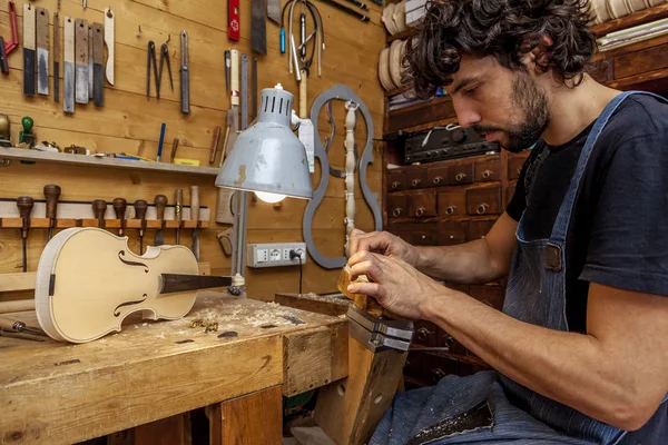 Usta violinmaker yeni bir keman onun atölyesinde çalışmaya başladı