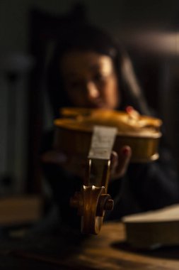 Genç kadın çırak violinmaker onun keman güzelliği kontrol