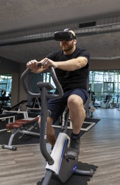 Artırılmış gerçeklik Görüntüleyicisi yoluyla arıyorsunuz bir egzersiz bisikleti pedal sportif adam