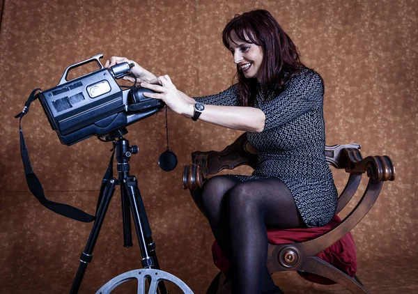 Piękna kobieta siedzi w studiu fotograficznym gry z kamerą — Zdjęcie stockowe