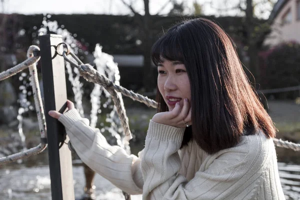 Ung kinesisk flicka slappnar av i en utomhuspark — Stockfoto