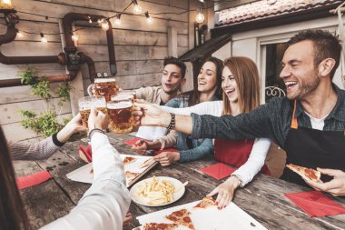 Mutlu arkadaş grubu bira içip pizza yiyor.