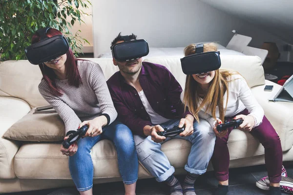 Joven feliz tres amigos jugando videojuegos realidad virtual — Foto de Stock