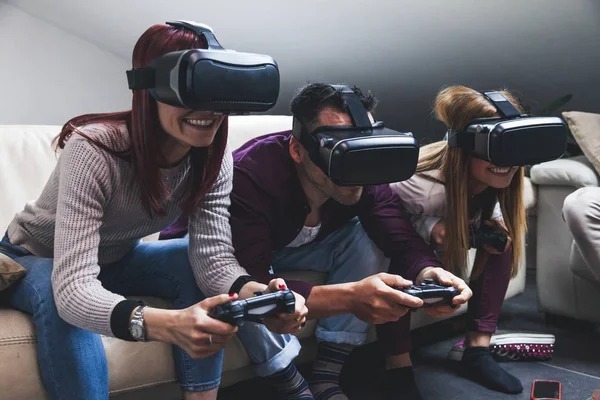 Joven feliz tres amigos jugando videojuegos realidad virtual — Foto de Stock