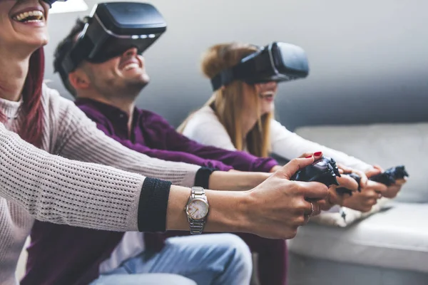 Joven feliz tres amigos jugando videojuegos realidad virtual — Foto de Stock