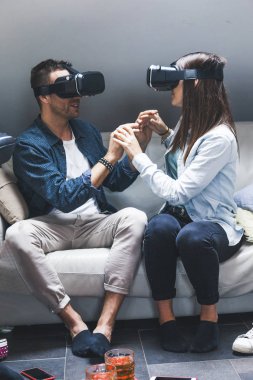 Young loving couple playing video games virtual reality glasses