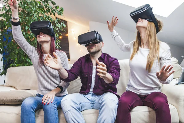 Joven feliz tres amigos jugando a los videojuegos de realidad virtual en — Foto de Stock