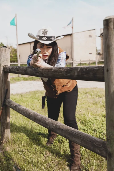 Porträtt av en vacker kinesisk kvinnlig cowgirl skytte med en w — Stockfoto