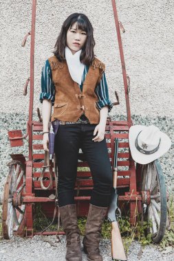 Güzel bir silahlı Çinli kadın cowgirl portresi