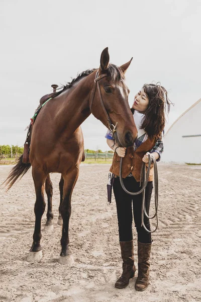 Cute chinese cowgirl while taking care of her horse — Stock Photo, Image