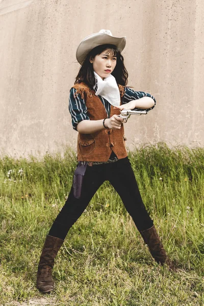 Porträtt av en vacker kinesisk kvinnlig cowgirl skytte med en g — Stockfoto