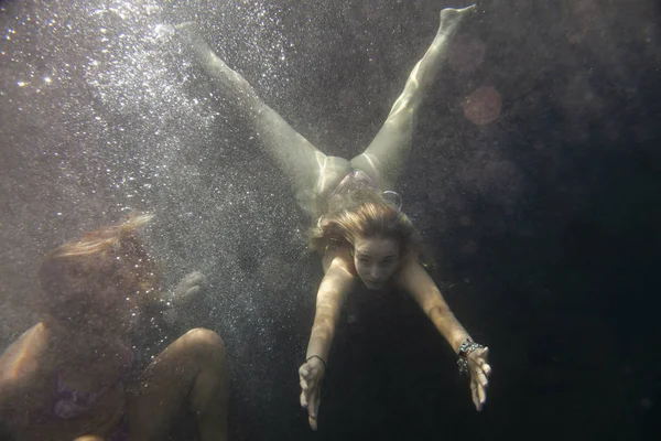 Duas mulheres bonitas nadando sob a água no mar transparente — Fotografia de Stock