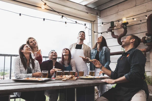 Mutlu arkadaş grubu bira içip bira fabrikasında pizza yiyor. — Stok fotoğraf