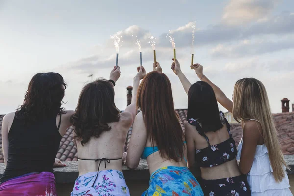 Gruppo di amiche felici che tengono scintille alla festa sul tetto — Foto Stock