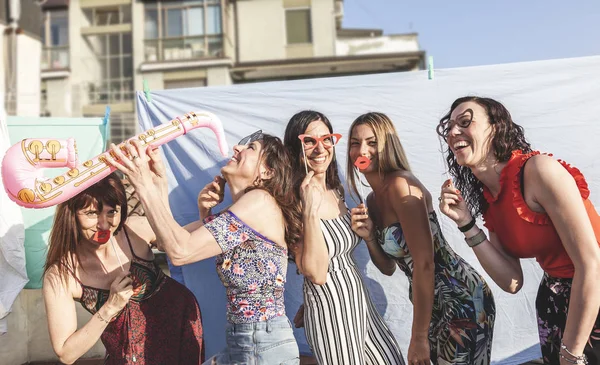 Gruppo di amiche che si divertono con accessori per feste sul — Foto Stock