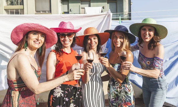 Gruppo di amiche che indossano cappelli tostati vino rosso — Foto Stock