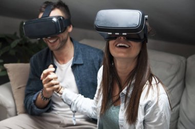Young loving couple playing video games virtual reality glasses