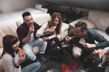 Mutlu arkadaş grubu bira içip pizza yiyor.
