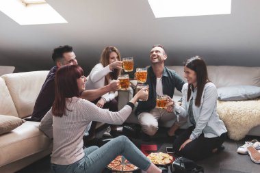 Mutlu arkadaş grubu bira içip pizza yiyor.