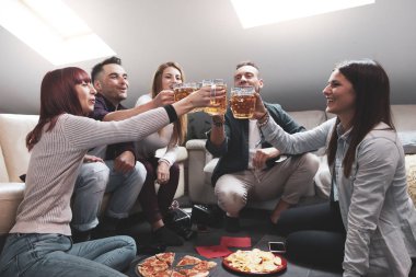 Mutlu arkadaş grubu bira içip pizza yiyor.