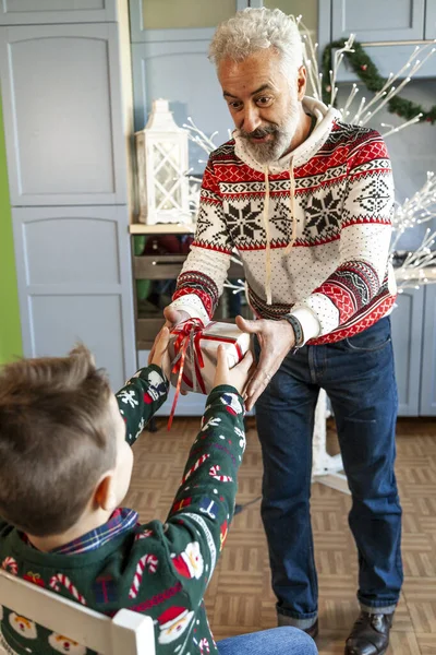 Nagyapa fehér szakállal kap egy karácsonyi ajándékot — Stock Fotó