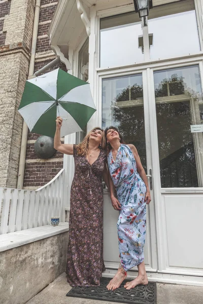 Couple of two attractive fifty year old women with umbrella — Stock Photo, Image