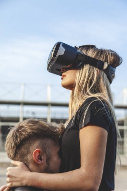Birbirlerine aşık güzel bir çift sanal gerçeklik gözlükleriyle sarılıyorlar.