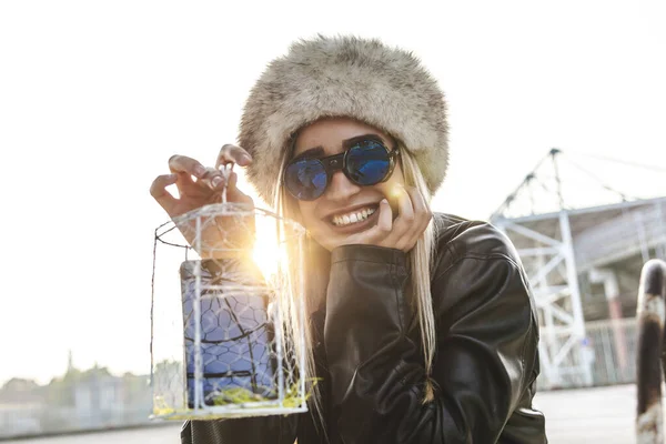 Giovane donna carina mentre mostra un telefono cellulare all'interno di un cag metallo — Foto Stock