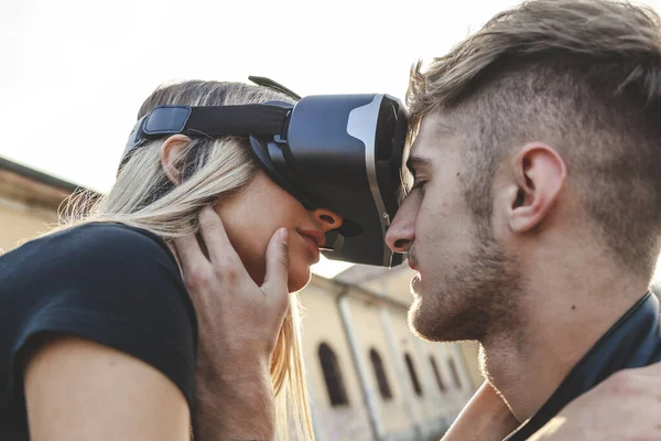 Hermosa pareja enamorada abrazándose con gafas de realidad virtual — Foto de Stock