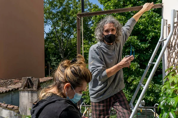 expert craftsman is repairing a balcony awning at the end of the coronavirus lockdown