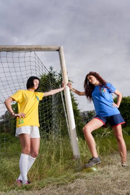 Brezilya ve İtalyan takımlarının bayan futbol atletleri spor sahasında antrenman yapıyorlar.